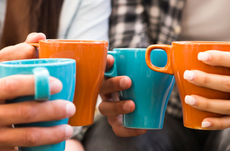 People drinking coffee from brightly coloured mugs
