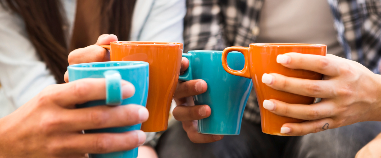 People drinking coffee from brightly coloured mugs